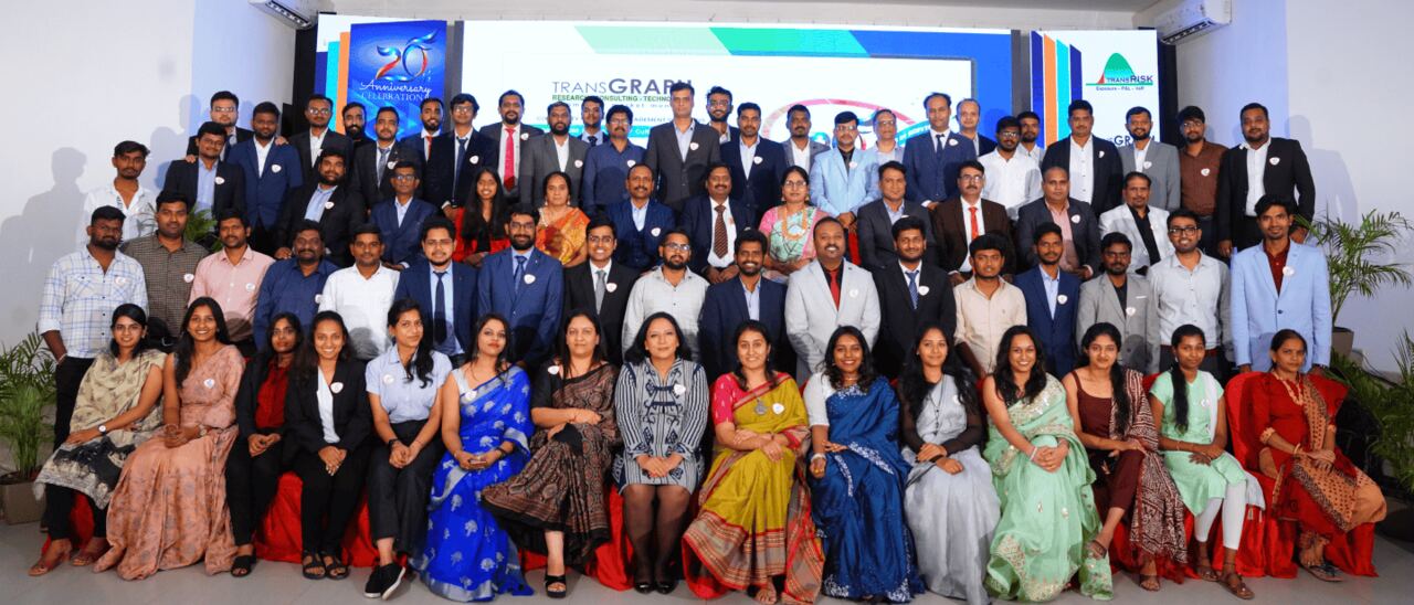 The TransGraph team at the company anniversary gathering, some eighty research, consulting and technology staff assembled in front of the TransGraph and TransRisk backdrop